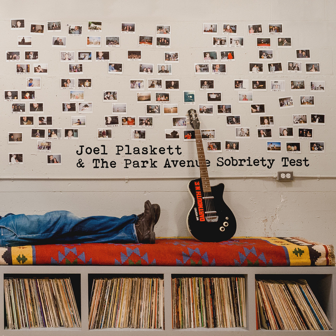 Joel Plaskett & the Park Avenue Sobriety Test album cover featuring a wall of polaroid images and a guitar below along with the lower legs of a man in blue jeans on an ornate rug